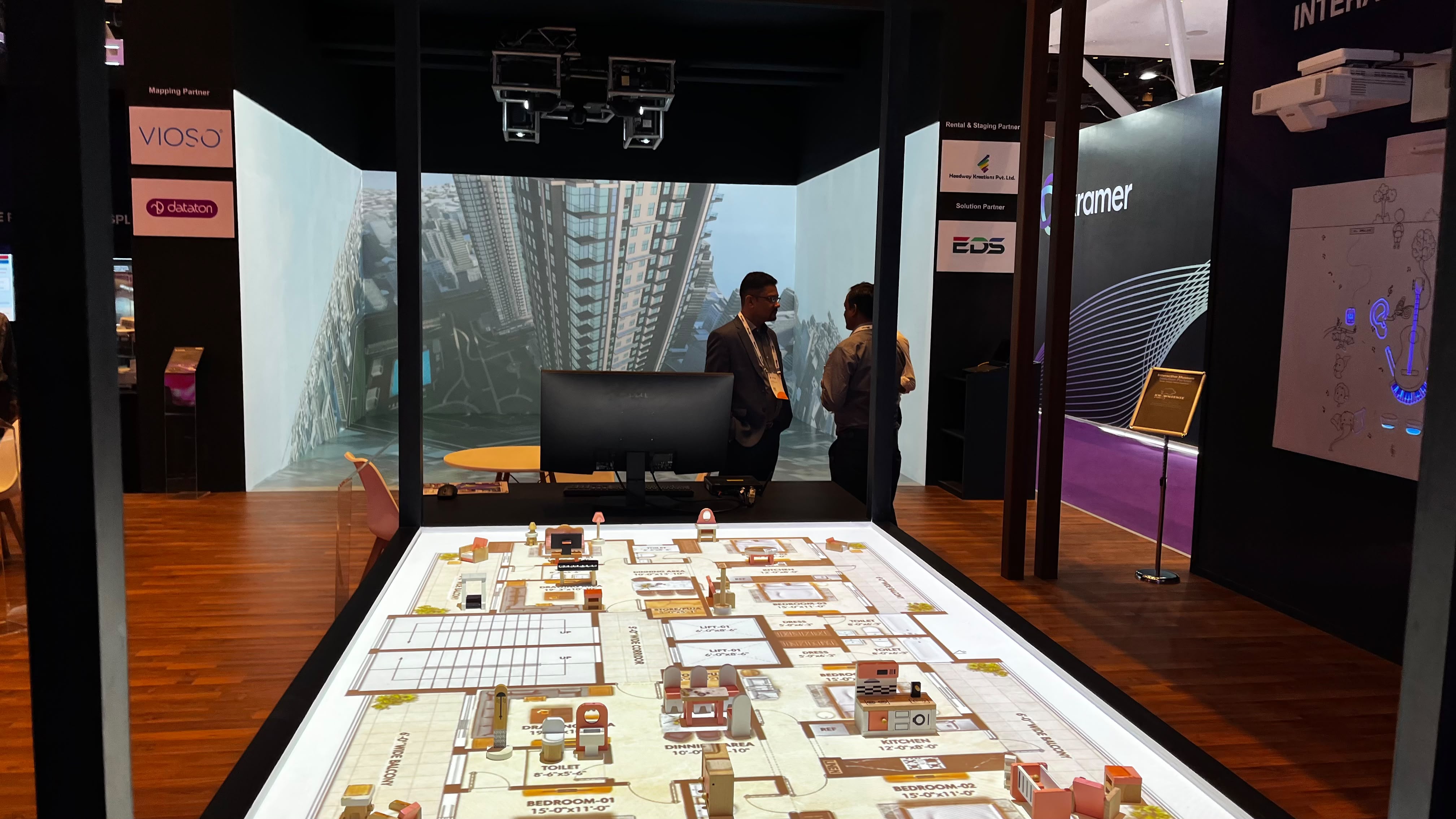 Projected tabletop plan in front of an immersive architectural display